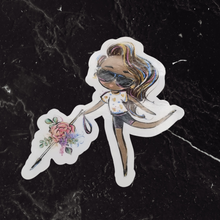 Load image into Gallery viewer, The Blind Woman with a White Cane sticker featuring the deep brown skin and brown hair option.on top of a black marble table.
