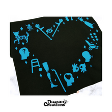 Load image into Gallery viewer, folded Disability Community Love T-Shirt on top of a marble table. Blue option