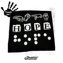 Load image into Gallery viewer, A black t-shirt says "Hope" in three different languages in white vinyl. The first line is "Hope" in Braille. The second line has "Hope" in English, and the third line has Hope in American Sign Language- fingerspelling. Raised vinyl used to be able to read love in Braille.