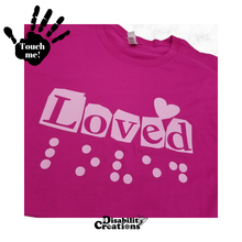 Load image into Gallery viewer, A folded berry shirt with pink design. On the top left is a black hand. On the palm, it says, "Touch me." The Disability Creations logo is at the bottom.