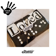 Load image into Gallery viewer, The tee inside a plastic bag with the Disability Logo on top. On the top left is a black hand. On the palm, it says, "Touch me." The Disability Creations logo is at the bottom.