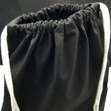 Load image into Gallery viewer, The top of the drawstring bag. The bag is black with white string handles.