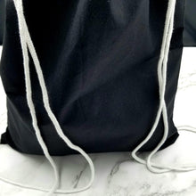 Load image into Gallery viewer, The back of the drawstring bag. The bag is black with white string handles.
