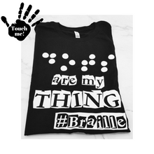 Load image into Gallery viewer, A black t-shirt says, "Dots are my thing #Braille" in white raised vinyl. The word "Dots" is in Braille. Raised vinyl used to be able to read "dots" in Braille. A hand on the top left corner that says, "touch me,"
