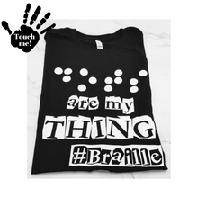 Load image into Gallery viewer, A black t-shirt says, &quot;Dots are my thing #Braille&quot; in white raised vinyl. The word &quot;Dots&quot; is in Braille. Raised vinyl used to be able to read &quot;dots&quot; in Braille. A hand on the top left corner that says, &quot;touch me,&quot;
