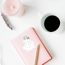 Load image into Gallery viewer, A fashionable feminine home office workspace with a  coffee mug, pink candle, and planner, The planner has a fireworks migraine sticker and a golden pen on it. 
