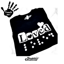 Load image into Gallery viewer, A folded black shirt with white design. On the top left is a black hand. On the palm, it says, &quot;Touch me.&quot; The Disability Creations logo is at the bottom.
