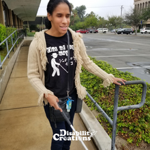 Load image into Gallery viewer, A female at the bottom of an accessible ramp holding her white cane. She is wearing the Out Of My Way T-Shirt! The Disability Creations Logo is at the bottom.
