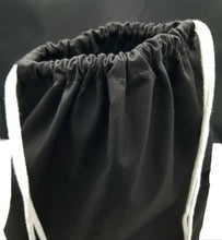 Load image into Gallery viewer, The top of the drawstring bag. The bag is black with white string handles.
