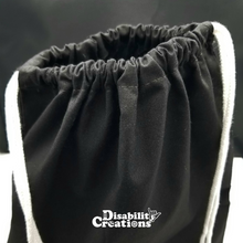 Load image into Gallery viewer, The top of the drawstring bag. The bag is black with white string handles.
