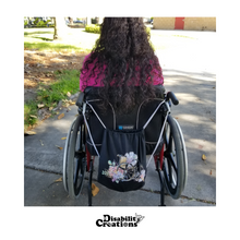 Load image into Gallery viewer, The bag is hanging on Nelly&#39;s wheelchair handles.

